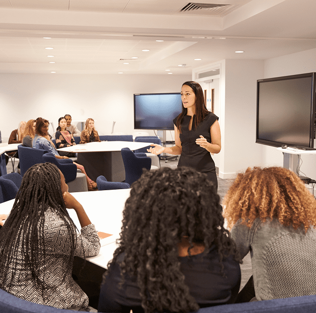 Woman presenting to group in conference room.